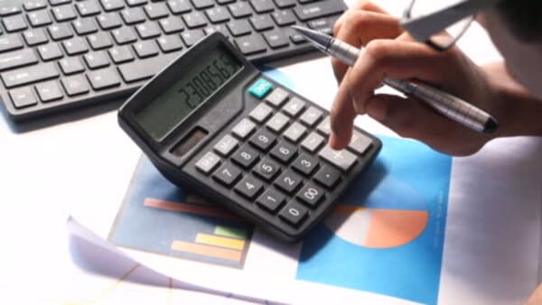 Persona revisando presupuesto con calculadora y notas